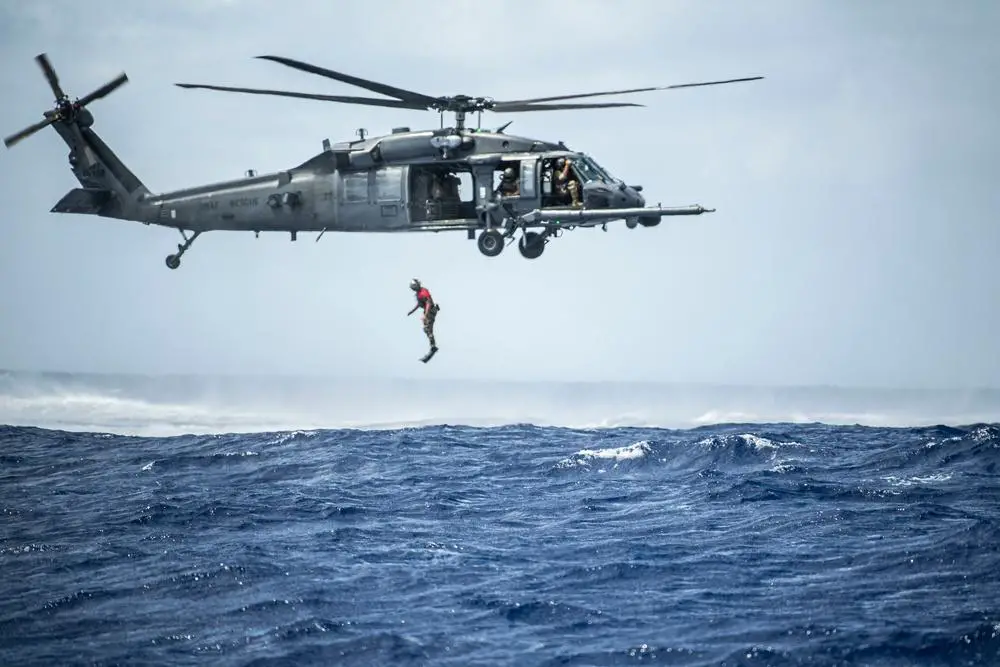 A U.S. Air Force pararescueman with the 31st Rescue Squadron jumps out of an HH-60G Pave Hawk from the 33rd Rescue Squadron during exercise Cope North 22 at the Island of Tinian near Andersen Air Force Base, Guam, Feb. 14, 2022. 