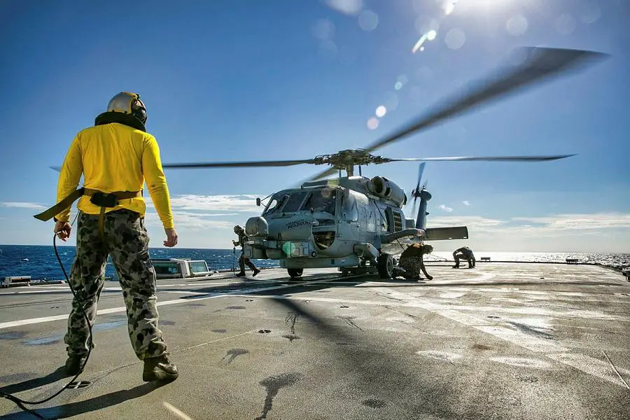Leading Seaman Aiden Muller marshals HMAS Arunta's flight deck crew during MH-60R Seahawk helicopter flying operations.