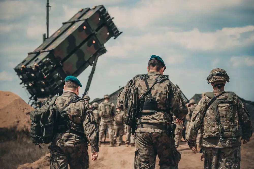 Service members from the U.S. Army and the Polish Land Forces walk to the site of the new Patriot missile system for a verbal demonstration of its operation and capabilities near Drawsko Pomorskie, Poland.