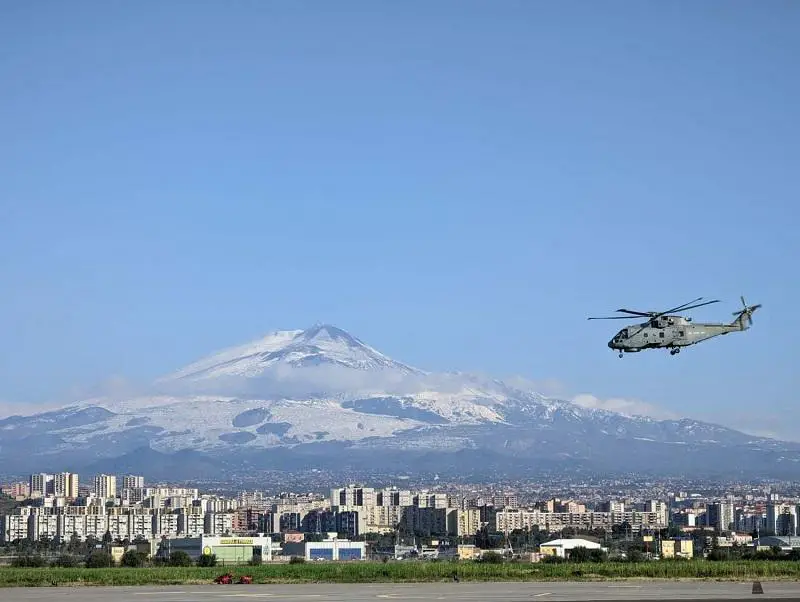 The 814 NAS Merlin returns to Sigonella with Catania and the snow-covered Mt Etna in the distance