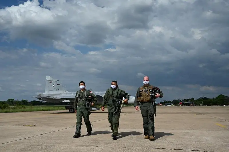 Exercise Directors for Exercise Cope Tiger 2022 Colonel (COL) David Kok, RSAF (left), Group Captain (GP CAPT) Sithipol Pomtri, RTAF (middle), and COL Wesley Hales, United States Air Force (USAF) (right) at the flight line in Korat Air Base, Thailand.