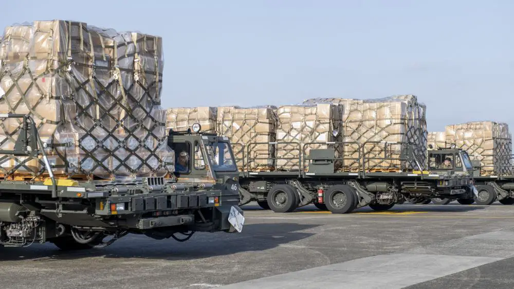 U.S. Air Force Airmen from the 730th Air Mobility Squadron wait on the base flight line with humanitarian aid cargo at Yokota Air Base, Japan, Mar. 16, 2022.