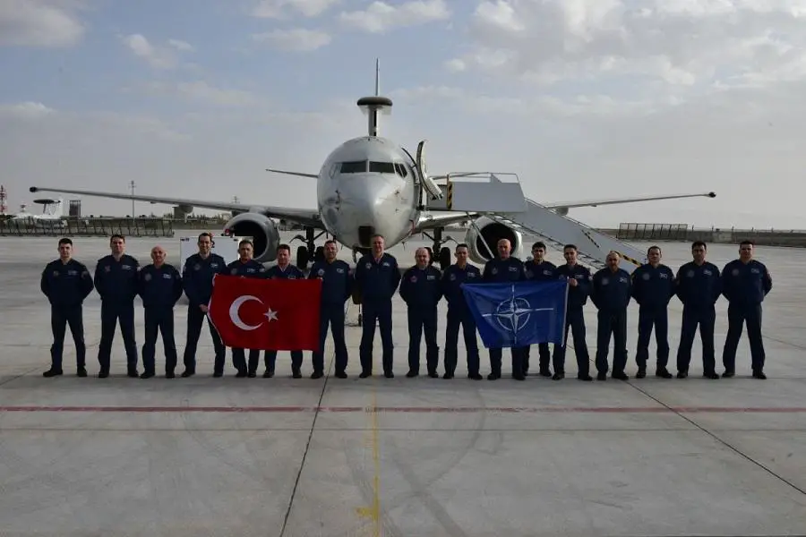 The crew of the E-7T stand in front of their aircraft displaying their Nation's flag beside a NATO flag.