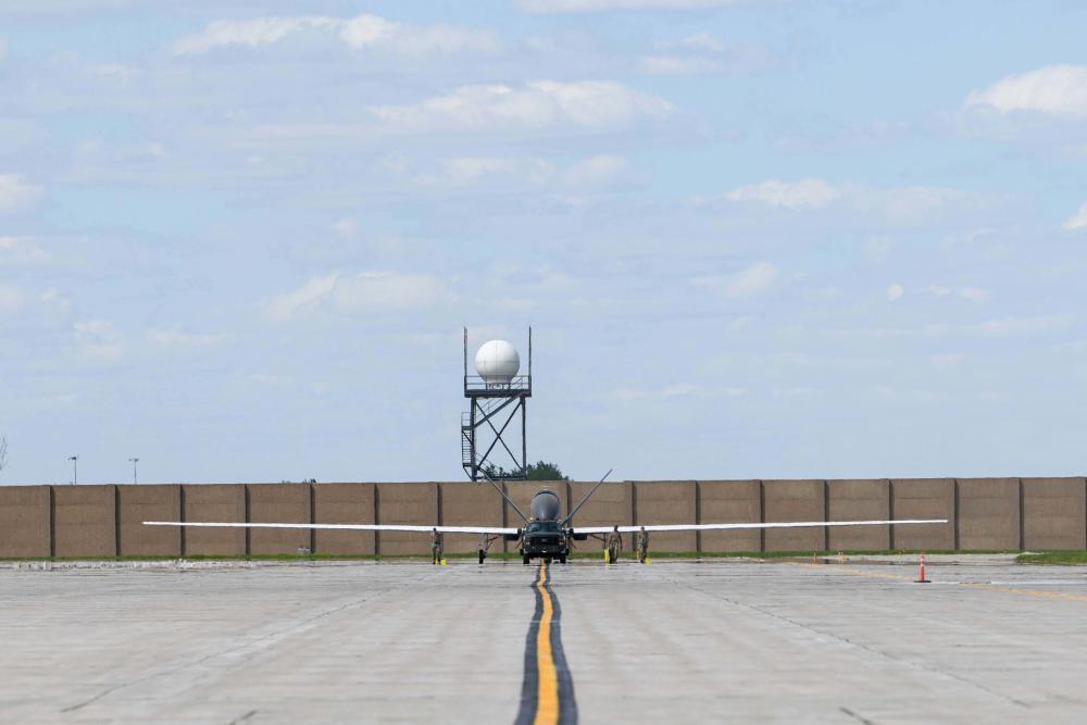 Airmen assigned to the 319th Aircraft Maintenance Squadron from Grand Forks Air Force Base, North Dakota, tow an RQ-4 Block 30 Global Hawk remotely piloted aircraft June 6, 2022, across the Grand Forks Air Force Base flight line to Northrop Grumman at Grand Sky. 