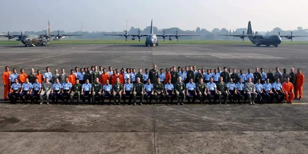 Airmen from the U.S. and Indonesian Air Forces gather in front of C-130 Hercules aircraft following the opening ceremony for Exercise Cope West 11 at Halim Air Base, Indonesia, June 20, 2011.