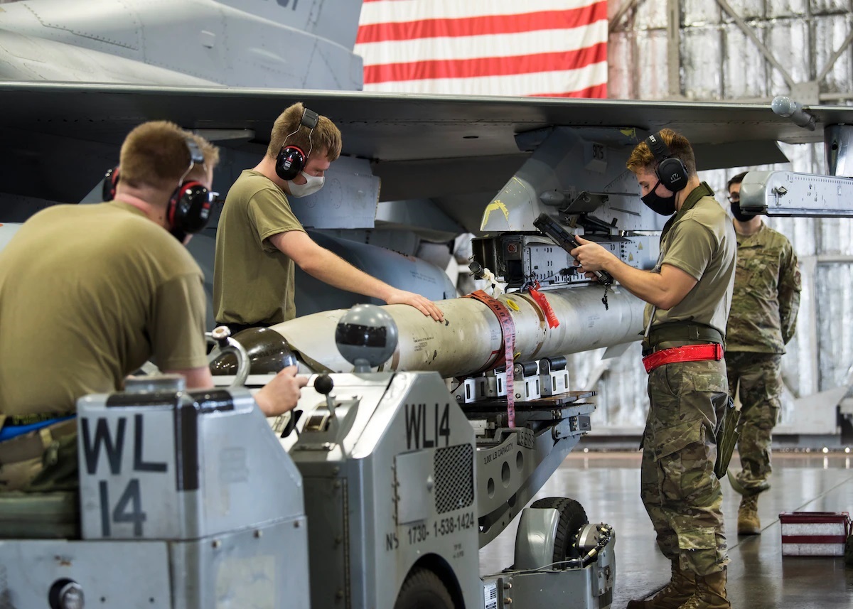 U.S. Air Force weapons load team members, from the 14th Aircraft Maintenance Unit, attach an AGM-88 HARM onto an F-16 Fighting Falcon and review technical orders during the second quarter load competition at Misawa Air Base, Japan, July 16, 2021.