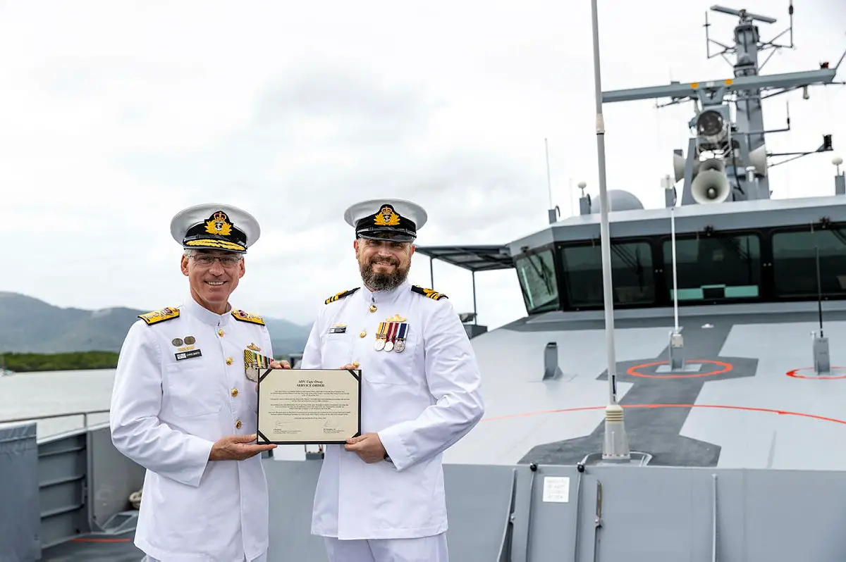 Deputy Chief of Navy Rear Admiral Christopher Smith, CSM, RAN, (left) presents Commanding Officer of Australian Defence Vessel Cape Otway, Lieutenant Commander James Thompson with a service order during an official welcome to home port HMAS Cairns.