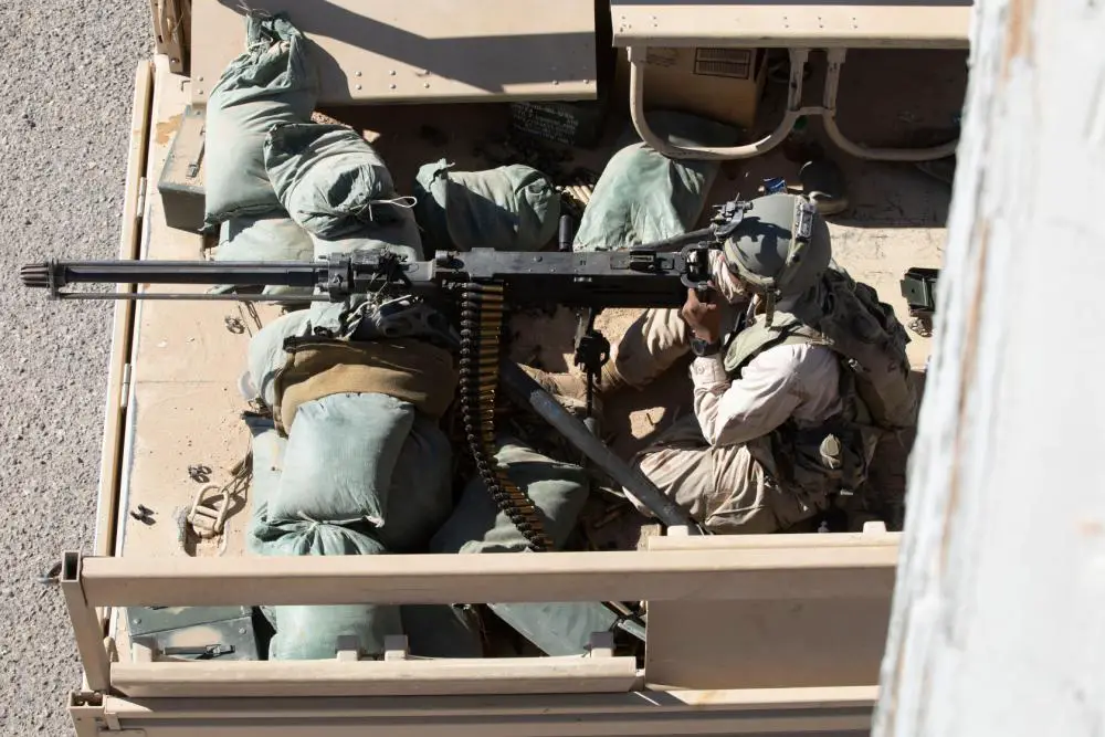 U.S. Army Soldier from the 11th Armored Cavalry Regiment, acting as an element of the Donovian Army, sets his sights through the view finder of a .50 caliber machine gun from the back of a 5-ton truck July 2, 2022, in the city of Razish, National Training Center, Fort Irwin, Calif.