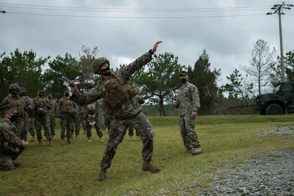 U.S. Marine Corps training instructor demonstrates to Marines with 3d Landing Support Battalion, 3d MLG, the proper deployment of an M67 Fragmentation Grenade on Range 30, Okinawa, Japan