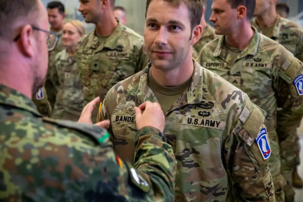 A U.S. Army paratrooper with with the 173rd Brigade Support Battalion, 173rd Airborne Brigade, receives the German Parachutist Badge after an airborne operation at Lake Constance, Germany, July 29, 2022. 75 paratroopers from the 173rd Airborne Brigade and 75 German paratroopers from the 26th Airborne Brigade ‘Saarland’ participated in the operation.