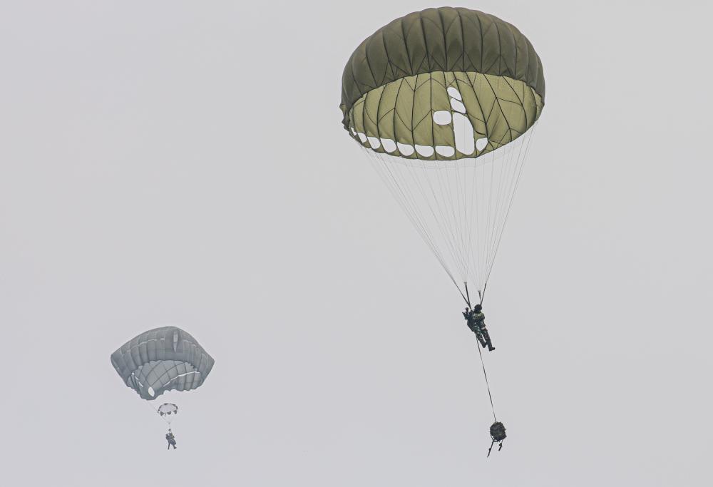 A U.S. Army paratrooper, and Tentara Nasional Indonesia Soldier prepare to land during joint airborne operations in Baturaja, Indonesia in support of Super Garuda Airborne on Aug. 3, 2022. 
