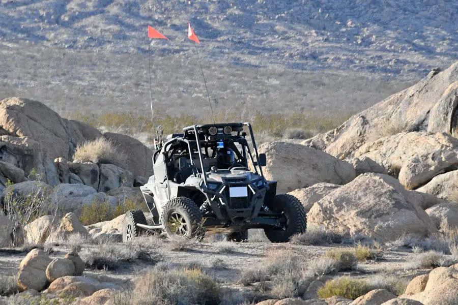 A RACER Fleet Vehicle demonstrating its ability to autonomously perform on a RACER course on representative terrain at Fort Irwin