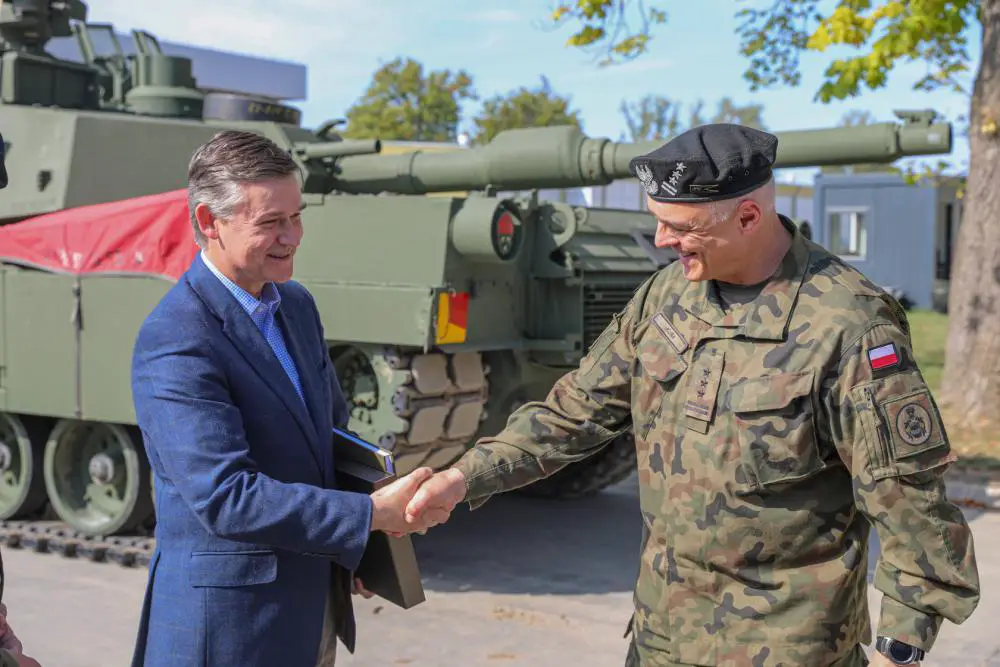 Assistant Secretary of the Army for Acquisition, Logistics and Technology, Douglas R. Bush, left, shakes hands with Polish Land Forces Col. Krzysztof Kuba, commander of the Polish Land Forces Training Center, after a tour of the Abrams Tank Training Academy at Biedrusko, Poland, Sept. 7, 2022. 