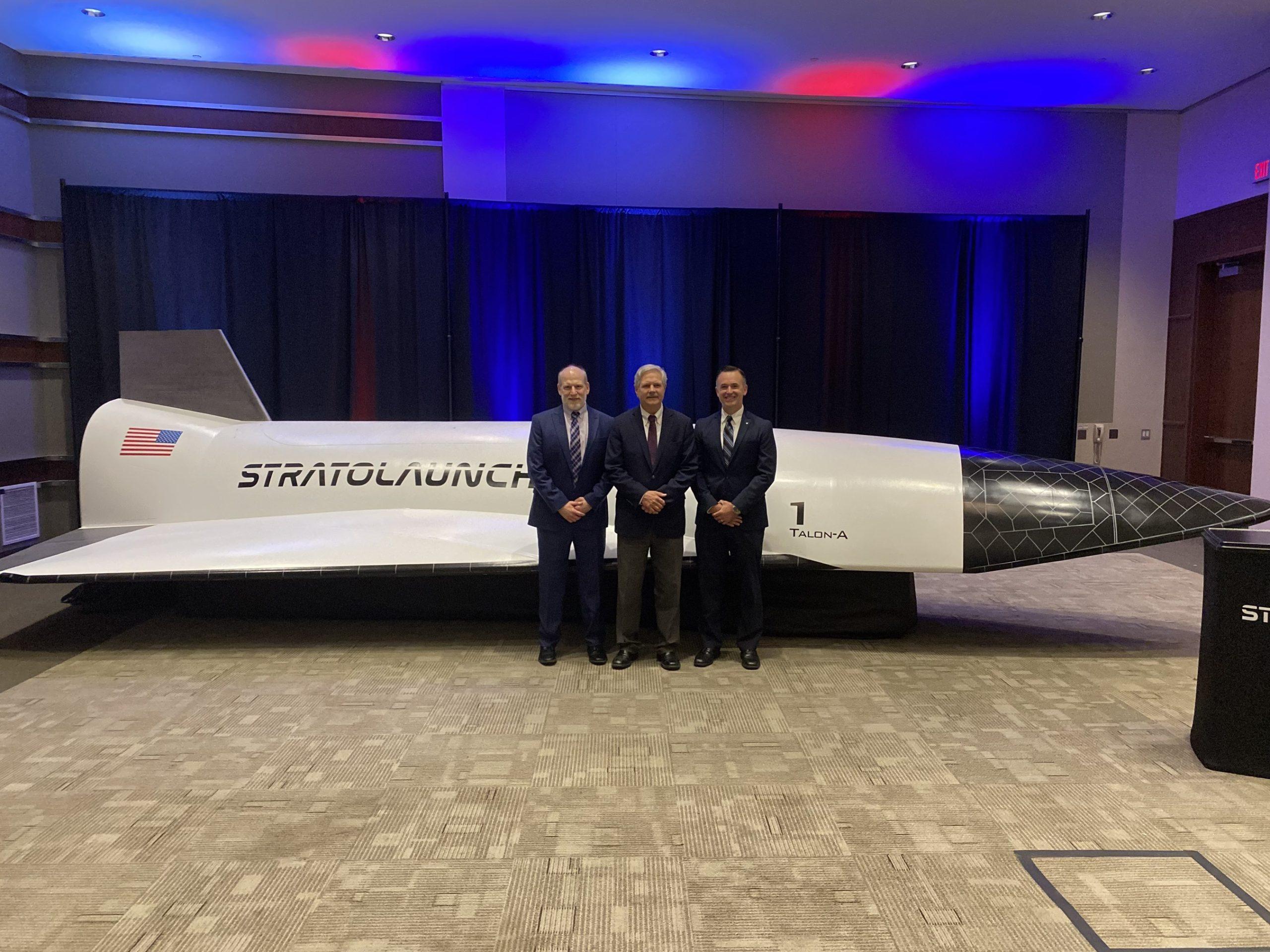 Test Resource Management Center Director George Rumford (left), U.S. Senator John Hoeven of North Dakota (center), and Stratolaunch CEO and President Dr. Zachary Krevor (right) unveiled the Talon-A vehicle replica and explained its role in the SkyRange program at the UAS Summit and Expo 2022 event on Oct. 4, 2022.