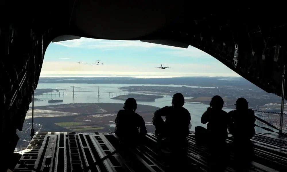 U.S. Air Force Airmen, assigned to the 14th Airlift Squadron and 1st Combat Camera Squadron, look out of a C-17 Globemaster III over Charleston, South Carolina, Jan. 5, 2023. Showcasing readiness and integration capabilities, Joint Base Charleston conducted the largest-ever formation of C-17 aircraft flying over the Arthur Ravenel Jr. Bridge in Charleston Harbor.