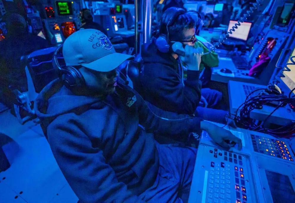  Fire Controlman (Aegis) 2nd Class Edwin Seeraj, from New York, left, mans the missile supervision system during a live fire exercise in the combat information center aboard Ticonderoga-class guided-missile cruiser USS Shiloh (CG 67). 