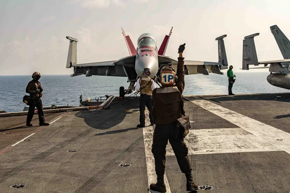 U.S. Navy Capt. Craig Sicola, commanding officer of the aircraft carrier USS Nimitz (CVN 68), front seat, and Cmdr. Luke Edwards, commanding officer of the "Fighting Redcocks" of Strike Fighter Squadron (VFA) 22, prepare for flight operations in an F/A-18F Super Hornet from VFA-22 on the flight deck.