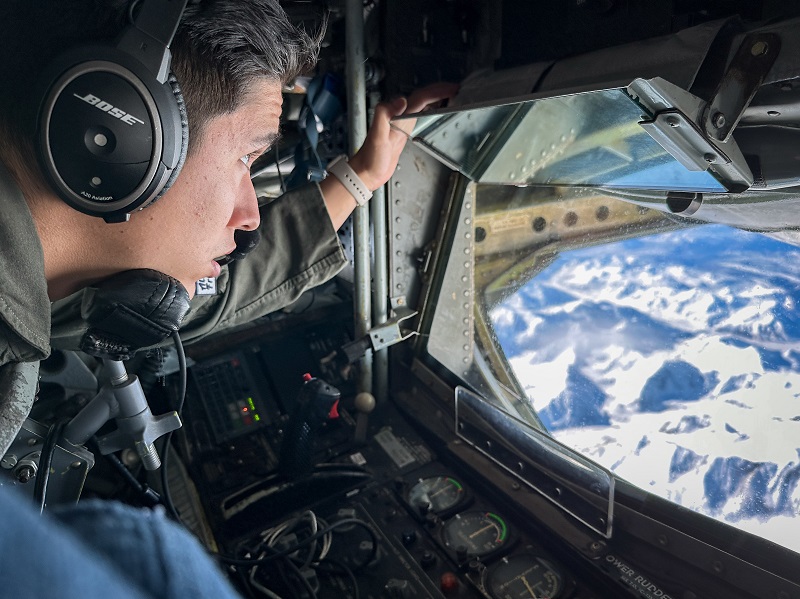 U.S. Air Force Airman 1st Class Joseph Saldana, a boom operator assigned to 50th Air Refueling Squadron, observes the Alaskan landscape during a refueling mission at Northern Edge 23-1 at Joint Pacific Alaska Range Complex, Alaska, May 18, 2023. Northern Edge provides a large-scale opportunity to enhance inter-service capabilities focused on joint combat operations in the Indo-Pacific region.