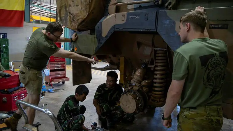 Soldiers from the Indonesian National Armed Forces Peacekeeping Centre conduct vehicle maintenance on a Bushmaster protected mobility vehicle.