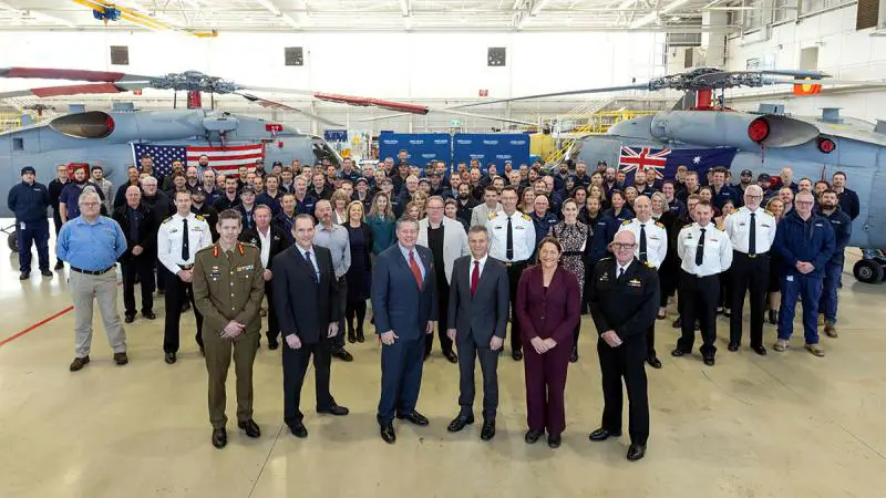Assistant Defence Minister Matt Thistlethwaite (third from right in front) marks the completion of deep maintenance on a US Navy MH-60R Seahawk 'Romeo' helicopter with Australian and US Defence and industry representatives in Nowra.