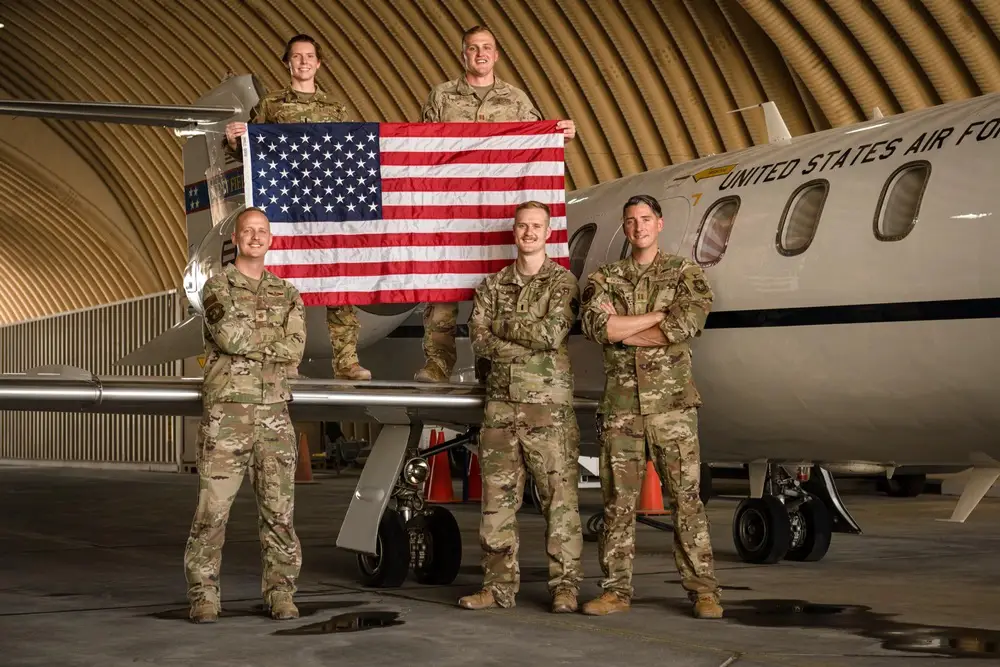 Members from the 912th Expeditionary Air Refueling Squadron C-21 Detachment take a group photo alongside a C-21A Learjet before its last flight out of Al Udeid Air Base, Qatar, June 30, 2023. 