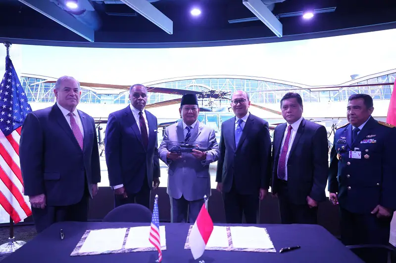 As Indonesian Defense Minister Prabowo Subianto (with hat) looks on, the Chairman of Dirgantara Indonesia, Gita Amperiawan (R), and Sikorsky's VP for global business development, Jeff White, sign a Heads of Agreement in Washington for the purchase of an unspecified number of S-70 Black Hawk helicopters for the Indonesian armed forces. 