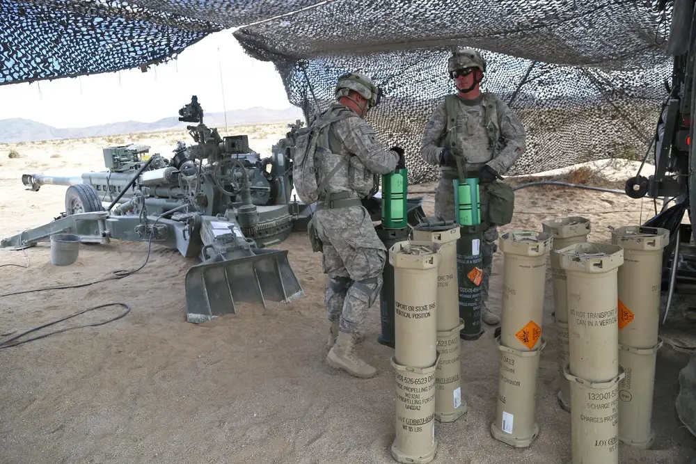 U.S. Army Soldier  prepare tubes of propelling charges for an M777 Howitzer during calibration at the National Training Center, Fort Irwin, California.