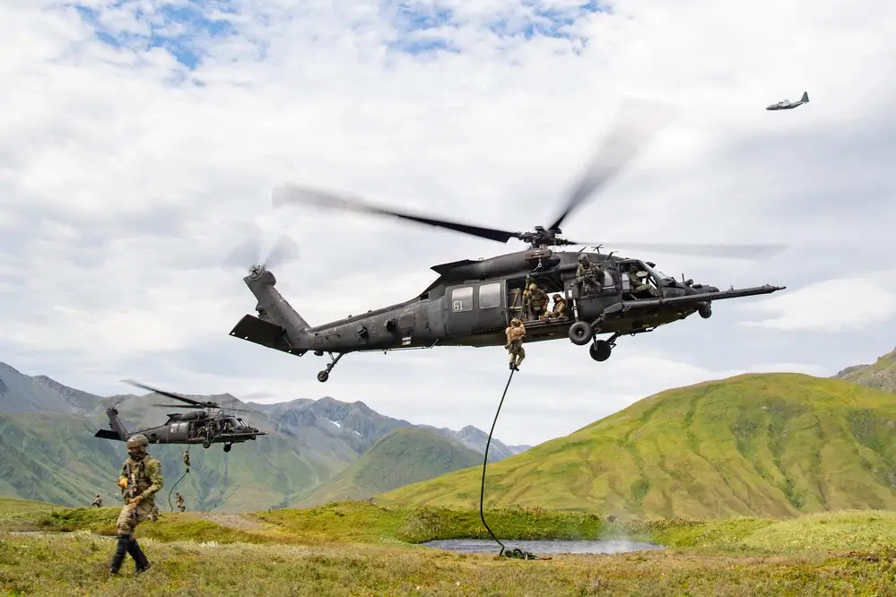 East-Coast-based U.S. Naval Special Warfare Operators (SEALs) fast-rope from U.S. Army MH-60M helicopters, assigned to the 160th Special Operations Aviation Regiment (SOAR), while an AC-130J Ghostrider, assigned to the 17th Special Operations Squadron, provides overwatch on Attu Island, Alaska
