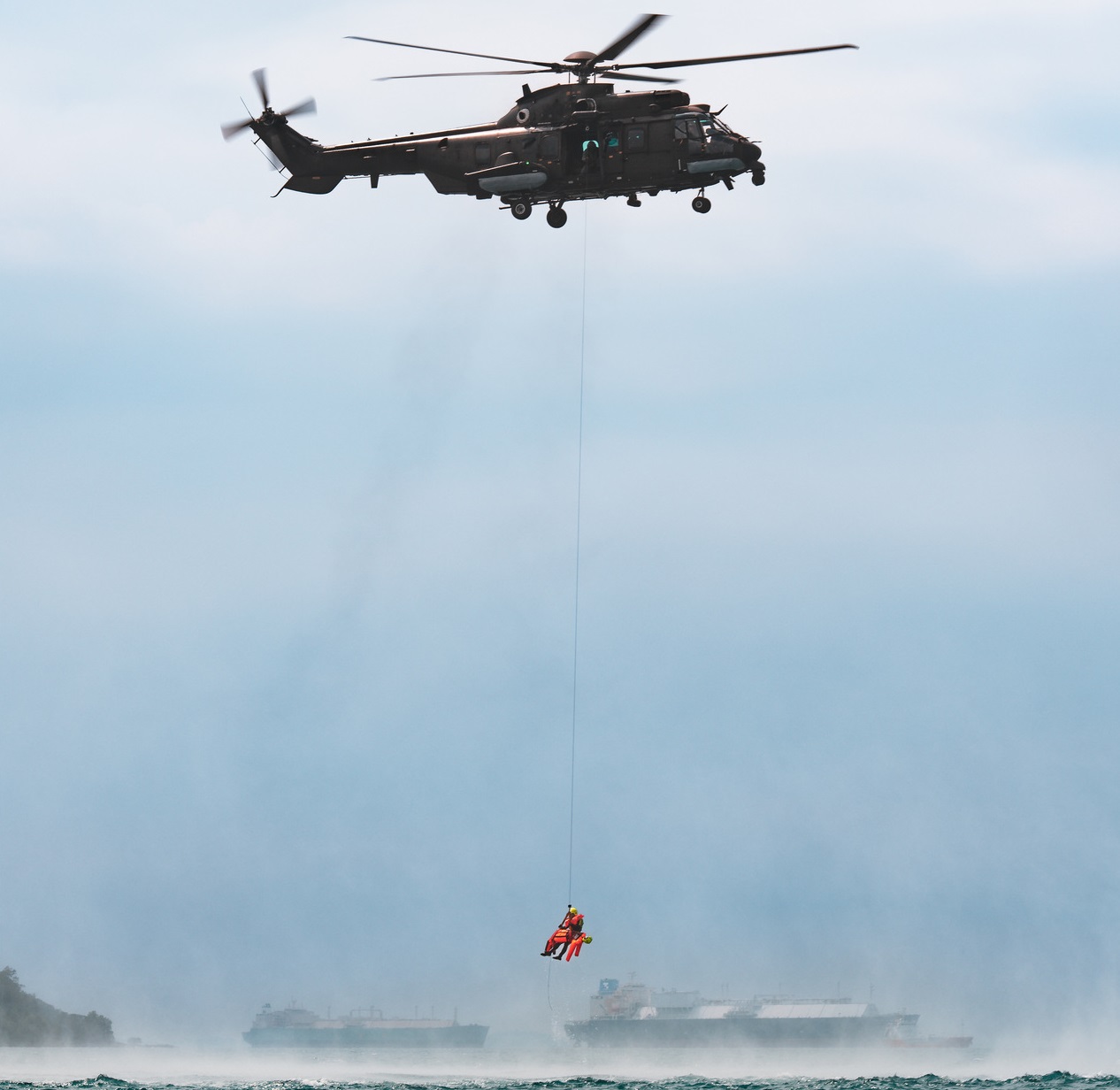 A simulated casualty being winched up to the RSAF's H225M helicopter in an aerial mishap scenario.