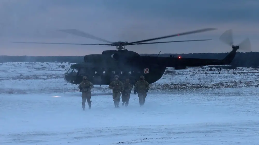 Combat medics from the 4th Battalion, 27th Field Artillery Regiment, 2nd Armored Brigade Combat Team, 1st Armored Division, dispatched from a Polish PZL W-3 Sokol helicopter after a successful casualty evacuation simulation during the US - Polish MARS 23 Live Fire Exercise in Toruñ, Poland on December 1, 2023.