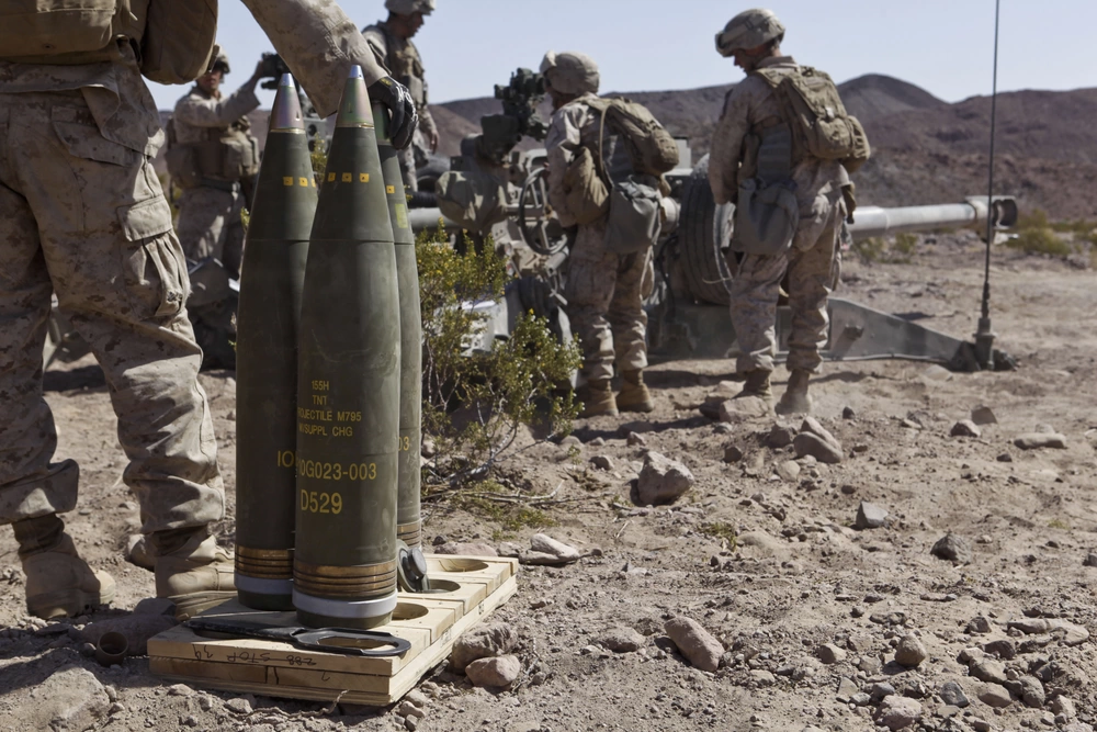 A U.S. Marine with Battery I, 3rd Battalion, 12th Marine Regiment stands ready to load an M795 High Explosive round into an M777 Lightweight 155mm Howitzer during the 11th Marine Regiment's Desert Fire Exercise aboard Marine Corps Air-Ground Combat Center 29 Palms, Calif