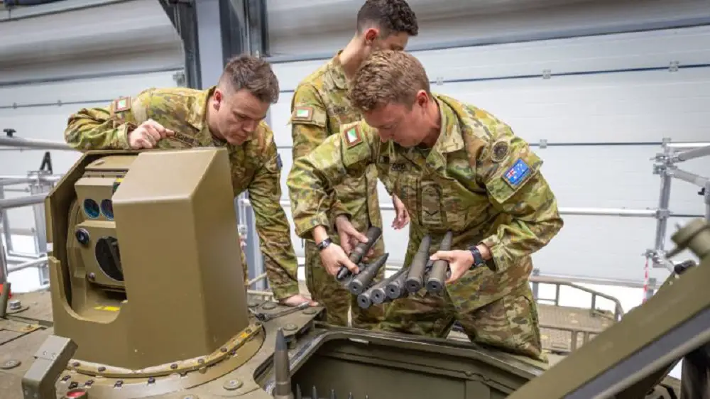 Sergeant Chris Hughes, Lance Corporal Ben Crawford and Trooper Liam Skinner reload the 30mm ammunition magazine on the Boxer.