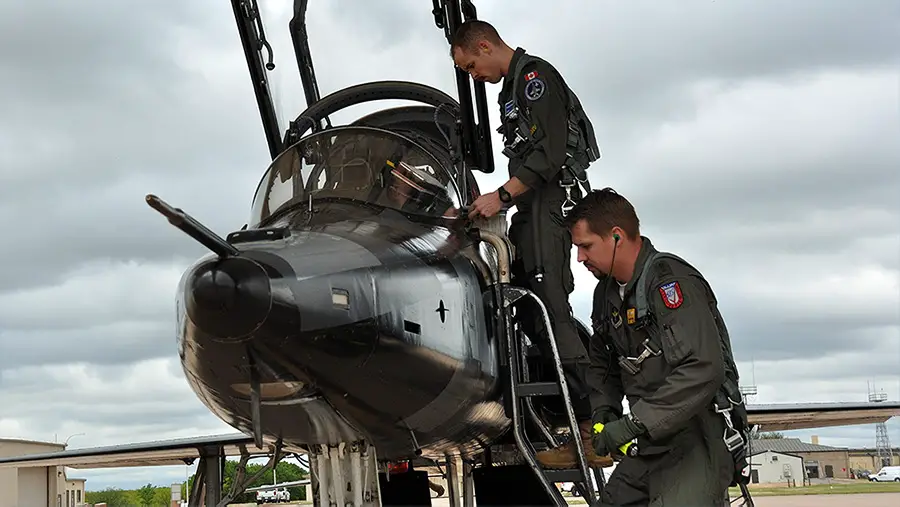 RCAF Captain Spencer Barkes (top) prepares for a flight in a T-38C at Sheppard Air Force Base, Texas, as part of training at the Euro-NATO Joint Jet Training Program.
