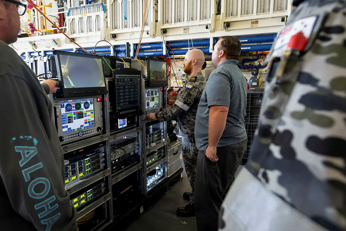 A Missile Defence Agency member, Steven Foster, shows Petty Officer Electronic Technician Thomas Dann how to control the ePATAS equipment in the Hanger of HMAS Stuart during the FTM-32 Mission as part of a Pacific deployment.