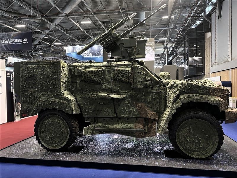 The hybrid electric JLTV (eJLTV), displayed in three Saab, Inc. camouflage covers: woodland.