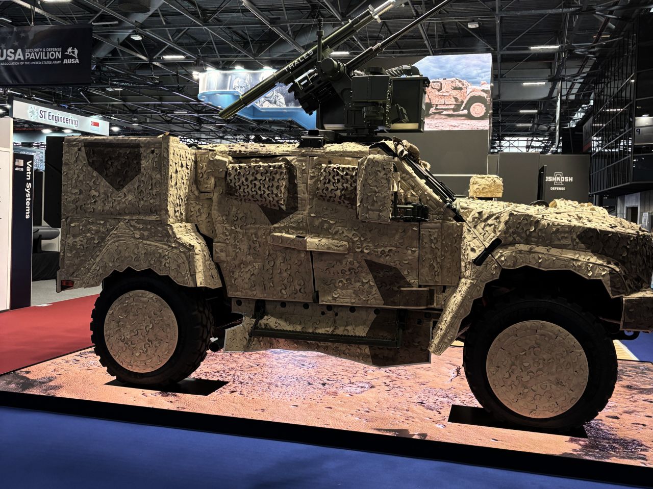 The hybrid electric JLTV (eJLTV), displayed in three Saab, Inc. camouflage covers: sand.