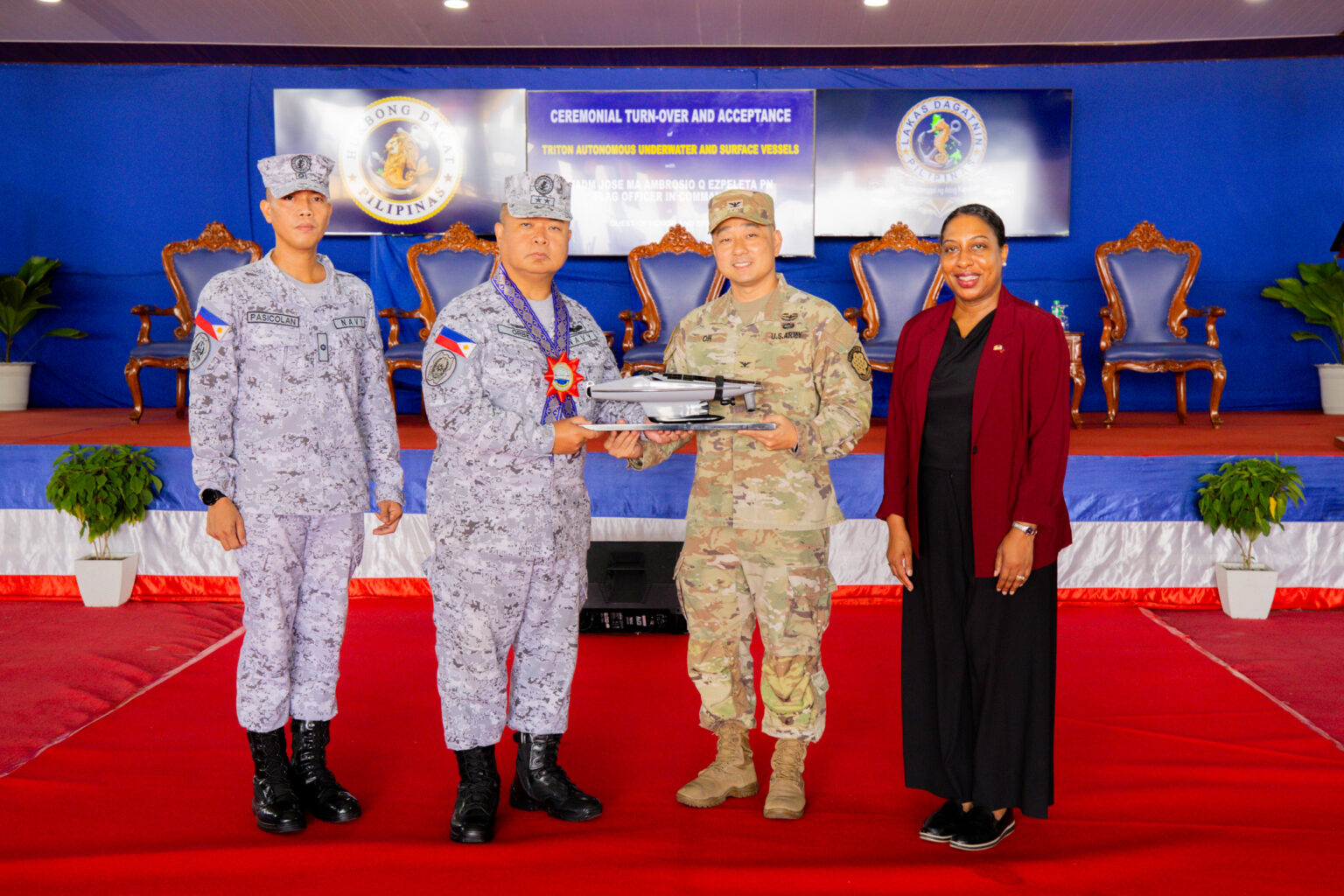 U.S. Embassy Senior Defense Official and Chief of the Joint US. Military Assistance Group-Philippines Colonel Daniel Oh (second from right) presents Philippine Fleet Commander Rear Admiral Joe Anthony Cabahug-Orbe (second from left) with a scale model of the Ocean Aero Triton autonomous underwater and surface vehicle during the turnover ceremony at the Philippine Navy’s Naval Operating Base Subic on June 22.
