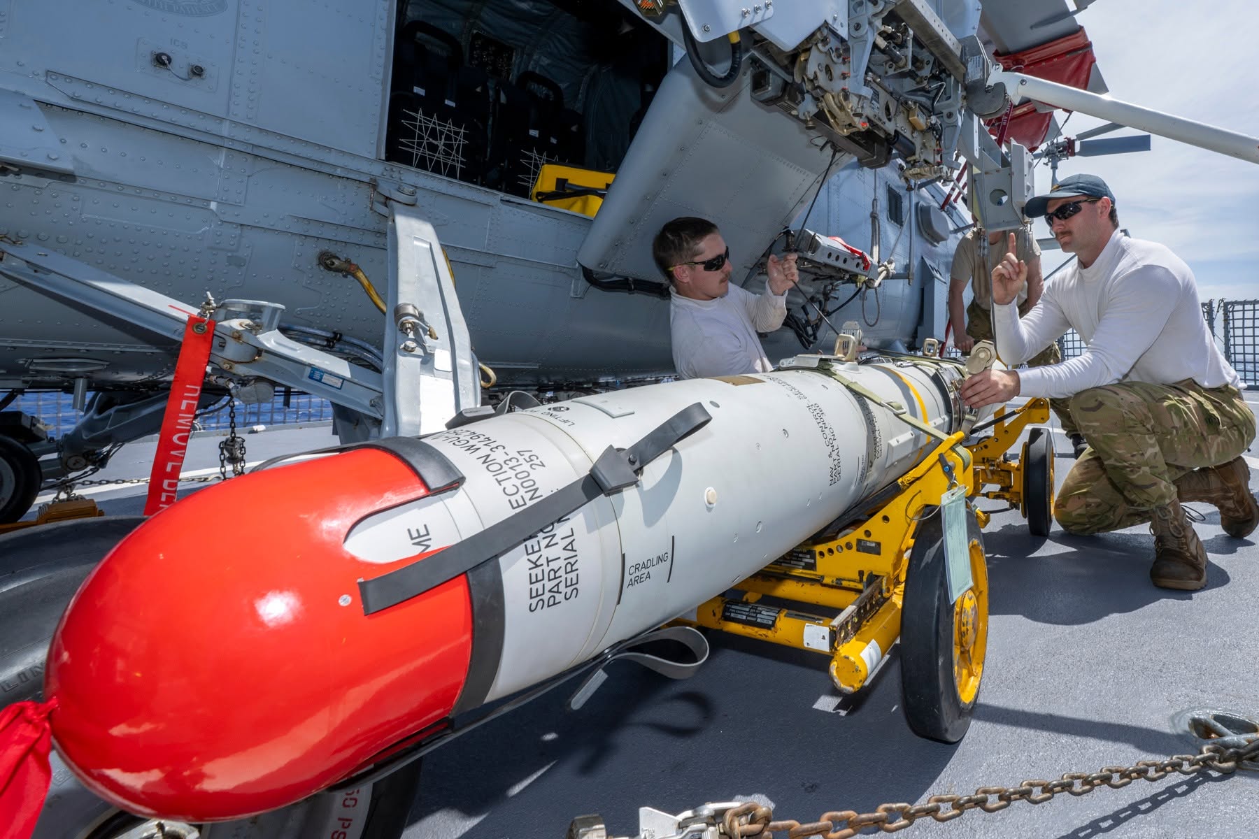 A Royal New Zealand Air Force armaments crew prepares to load an AGM-119 Penguin anti-ship missile onto an SH-2G(I) Super Seasprite maritime helicopter