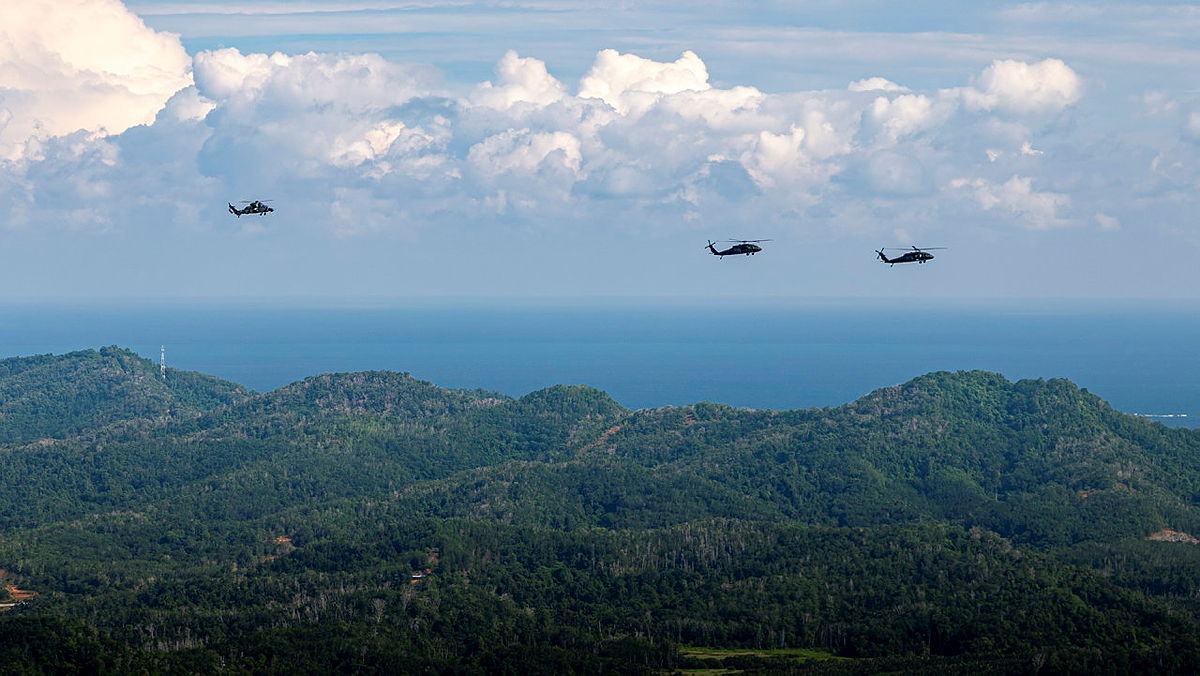 An Australian Army Tiger Armed Reconnaissance helicopter escorts two United States Army UH-60M Black Hawks during a mission as part of Exercise Keris Strike 26 in Sabah, Malaysia.